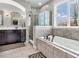 Bright bathroom with tub under window, walk-in shower, and vanity sink at 10603 Hinterland Dr, Fishers, IN 46038