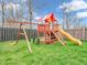 Backyard playground with a swing set, climbing structure, and slide, perfect for Gathering fun, set against privacy fence at 10603 Hinterland Dr, Fishers, IN 46038