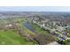 Expansive aerial view of a residential neighborhood with a serene pond and lush green spaces at 11050 Midnight Pass, Fishers, IN 46037