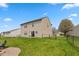 Spacious fenced backyard featuring a patio and lush green grass with vibrant yellow wildflowers at 1167 Dark Star Ct, New Whiteland, IN 46184