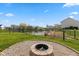 Backyard fire pit with gravel and stone and serene water view, perfect for outdoor enjoyment at 1167 Dark Star Ct, New Whiteland, IN 46184