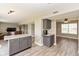 Open-concept kitchen featuring stainless steel appliances, granite countertops, gray cabinets, and wood-look floors at 1167 Dark Star Ct, New Whiteland, IN 46184