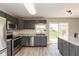 Updated kitchen featuring stainless steel appliances, granite countertops, gray cabinets, and a sliding glass door at 1167 Dark Star Ct, New Whiteland, IN 46184