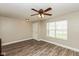 Bright living room featuring wood-look flooring, a ceiling fan, and a window offering natural light at 1167 Dark Star Ct, New Whiteland, IN 46184