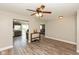 Open-concept living space featuring wood-look floors, a ceiling fan, and an adjoining kitchen at 1167 Dark Star Ct, New Whiteland, IN 46184