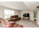 Comfortable living room with leather seating, wood-look flooring, and natural light from the window at 1167 Dark Star Ct, New Whiteland, IN 46184
