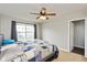 Bedroom featuring a ceiling fan, large window, and comfortable-looking bed with a patterned quilt at 1167 Dark Star Ct, New Whiteland, IN 46184