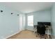 A light blue office/bedroom features a door, window and desk with dual monitors at 1167 Dark Star Ct, New Whiteland, IN 46184