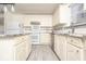Bright kitchen featuring white cabinetry, granite countertops, and modern appliances at 12344 Bearsdale Dr, Indianapolis, IN 46235