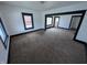 Spacious living room featuring neutral carpet, bright white walls, and dark trim at 1524 Ohio Ave, Anderson, IN 46016