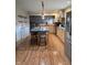 Bright kitchen with wood floors, stainless steel refrigerator, granite island with seating, and stainless steel appliances at 16371 State Road 38 E, Noblesville, IN 46060