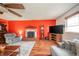 A cozy living room area featuring hardwood floors, a ceiling fan, and a unique red accent wall at 16371 State Road 38 E, Noblesville, IN 46060