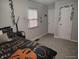 Bright bedroom with a decorative bed, gray walls, and a window with blinds at 1806 Asbury St, Indianapolis, IN 46203