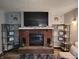 Cozy Gathering room boasts a brick fireplace, TV, wall decals, and built-in shelving at 1806 Asbury St, Indianapolis, IN 46203