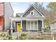 Charming home featuring a gray exterior with a bright yellow front door at 2006 Lexington Ave, Indianapolis, IN 46203