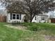 Inviting home exterior with green shutters, flowering trees and shrubbery enhancing curb appeal in a verdant front yard at 265 Bittersweet Dr, Whiteland, IN 46184