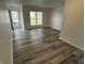 Bright, airy living room featuring modern vinyl floors, fresh white paint and ample natural light streaming through the window at 265 Bittersweet Dr, Whiteland, IN 46184