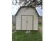 Well-maintained storage shed in backyard with double doors and neutral siding, providing ample space for tools and equipment at 265 Bittersweet Dr, Whiteland, IN 46184