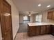 Bright kitchen with wood cabinets, white countertops, and open view to the large carpeted living area at 2856 Colony Lake East Dr, Plainfield, IN 46168