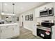 Modern kitchen with white cabinets, stainless steel appliances, a breakfast bar, and a clear view into the living room at 2915 E 19Th St, Indianapolis, IN 46218
