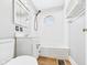 Well-lit bathroom with a white tiled shower-tub, vanity, and wood-look vinyl flooring at 2920 Lincoln St, Anderson, IN 46016
