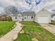 A charming house featuring vinyl siding, a lush lawn, and a convenient detached one-car garage at 2920 Lincoln St, Anderson, IN 46016