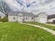Charming single-story home with gray siding, well-maintained lawn, and a detached one-car garage at 2920 Lincoln St, Anderson, IN 46016