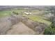 Wide aerial shot displays farm buildings and houses surrounded by agricultural land and trees at 3110 S County Road 225 East, Danville, IN 46122