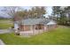 Brick home featuring an expansive deck, attached garage, and well-maintained lawn surrounded by mature trees at 3110 S County Road 225 East, Danville, IN 46122