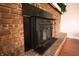 Close up on a brick fireplace with a black metal insert and mantel at 3110 S County Road 225 East, Danville, IN 46122
