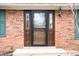 Inviting front entryway with a stylish storm door framed by sidelights, set in a classic brick facade with green shutters at 3110 S County Road 225 East, Danville, IN 46122