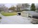 Exterior view of a two-car garage and outbuilding with gravel driveway, plus trailer in yard at 3110 S County Road 225 East, Danville, IN 46122