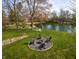 Lush backyard with lake access and an outdoor fire pit sitting on a well manicured lawn at 315 Sunset Dr, Columbus, IN 47201