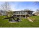 Large backyard with stone terracing and an outdoor fire pit sitting on a well manicured lawn at 315 Sunset Dr, Columbus, IN 47201
