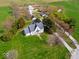 Picturesque aerial view of a charming farmhouse with multiple outbuildings, surrounded by lush greenery and mature trees at 3308 S 600 E Rd, Waldron, IN 46182