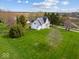 Expansive aerial shot showcasing a well-manicured lawn and two-story farmhouse nestled in a serene, rural setting at 3308 S 600 E Rd, Waldron, IN 46182