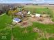 Wide aerial view showcasing a complete farm setup including a house, barn, silos, and open fields at 3308 S 600 E Rd, Waldron, IN 46182