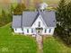 Detailed front view of a two-story farmhouse featuring classic architectural design and a well-maintained lawn at 3308 S 600 E Rd, Waldron, IN 46182
