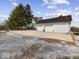 A three-door garage with white siding sits on a spacious concrete pad at 3308 S 600 E Rd, Waldron, IN 46182