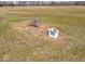 Rural landscape with a small outbuilding and natural debris pile in a grassy field with trees in the background at 3308 S 600 E Rd, Waldron, IN 46182