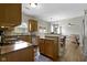 Open kitchen with stainless appliances, wood cabinets and breakfast bar with view to dining area at 3511 Limesprings Ln, Whitestown, IN 46075