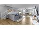 Open-concept living room featuring hardwood floors, comfortable seating, and staircase access at 3511 Limesprings Ln, Whitestown, IN 46075
