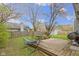 Large, fenced backyard with a wooden deck, outdoor furniture, and mature trees at 3724 W 42Nd Ter, Indianapolis, IN 46228