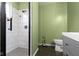 Clean bathroom featuring a tiled shower, neutral green walls, toilet, and modern fixtures at 3724 W 42Nd Ter, Indianapolis, IN 46228