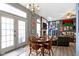 Dining room with wood table, chairs, chandelier, and luxury vinyl plank flooring connected to living room and backyard at 3724 W 42Nd Ter, Indianapolis, IN 46228