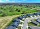 Aerial view showcasing a neighborhood bordering a picturesque golf course with verdant fairways and manicured greens at 4941 Oak Hill Dr, Lebanon, IN 46052