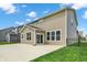 View of the house's rear exterior with large windows, door and concrete patio, surrounded by grass at 4941 Oak Hill Dr, Lebanon, IN 46052