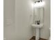 Simple half bathroom with a pedestal sink, mirror, and modern fixtures in a bright, clean space at 4941 Oak Hill Dr, Lebanon, IN 46052
