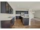 Modern kitchen boasts dark cabinets, stainless steel appliances, and a large center island with an eat-in counter at 4941 Oak Hill Dr, Lebanon, IN 46052