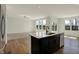 Modern kitchen with stainless steel appliances, a large island, dark cabinets, and a view to the living room at 4941 Oak Hill Dr, Lebanon, IN 46052